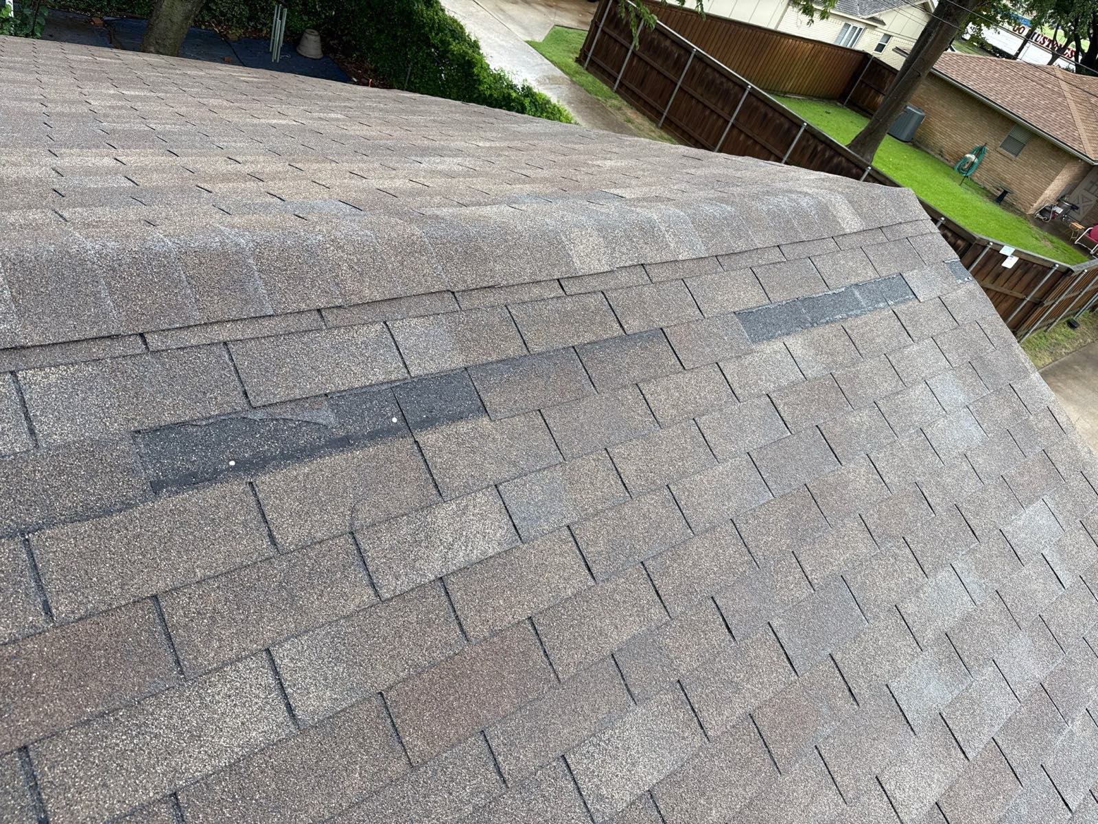 Dark patch on a slope where shingles are missing