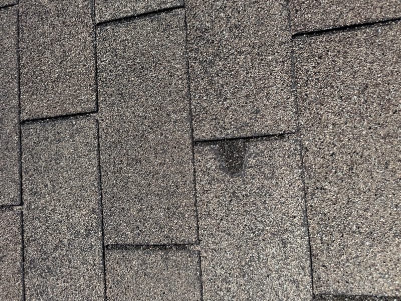 Single hail impact mark on an asphalt shingle