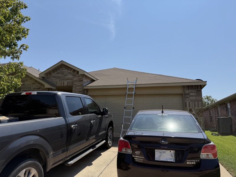 Brick home with the ladder up and the truck on the drive