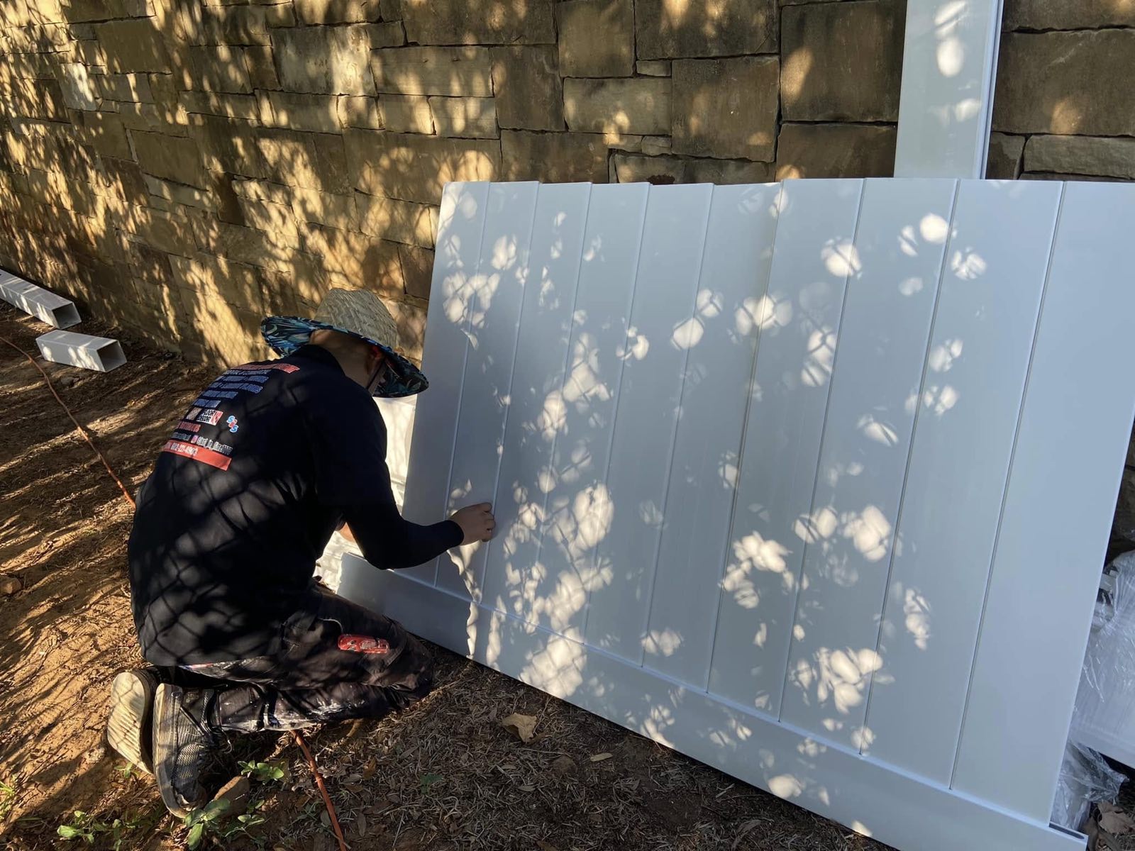Setting a vinyl privacy fence panel