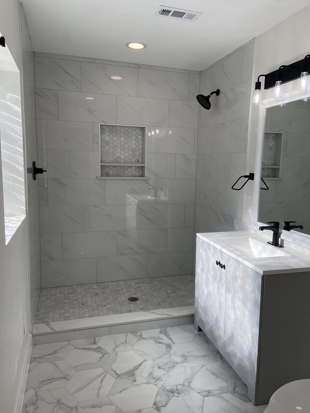 Walk in tile shower with niche and new vanity